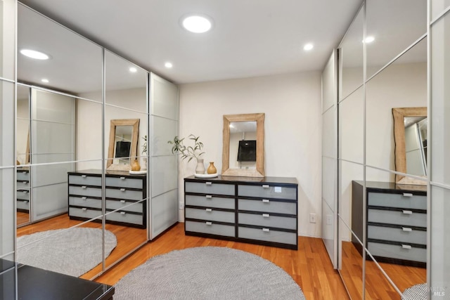 walk in closet with wood finished floors