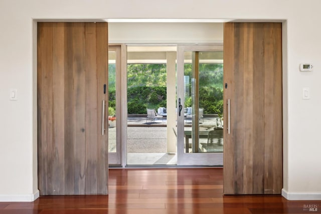 entryway with baseboards and wood finished floors