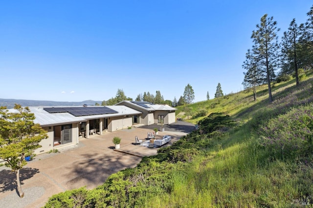 4127 Dry Creek Rd, Napa, CA 94558 - back of house featuring roof mounted solar panels, a patio area, and stucco siding