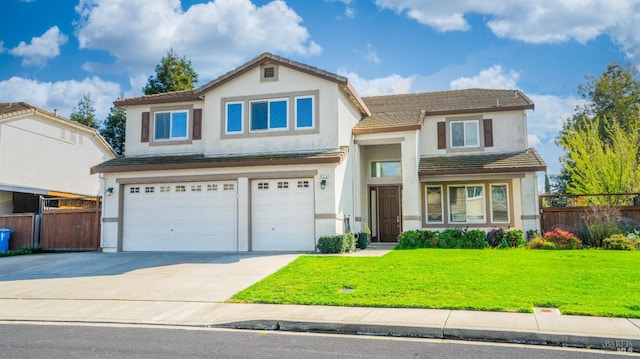 traditional home featuring stucco siding, a front lawn, driveway, fence, and a garage