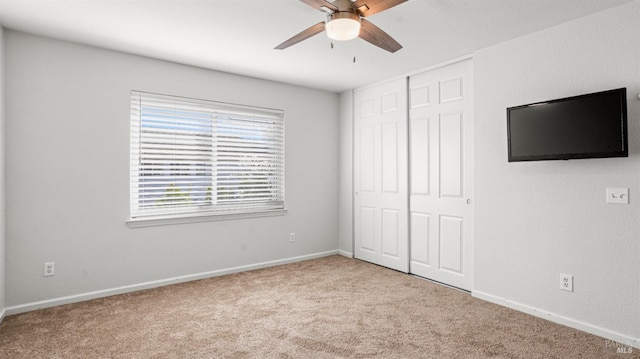 unfurnished bedroom featuring a closet, carpet floors, baseboards, and ceiling fan