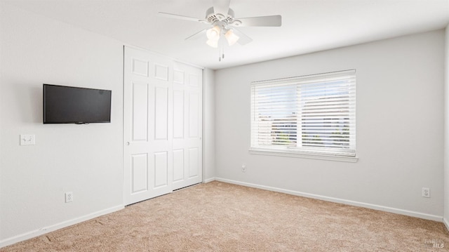 unfurnished bedroom featuring a closet, baseboards, a ceiling fan, and carpet flooring