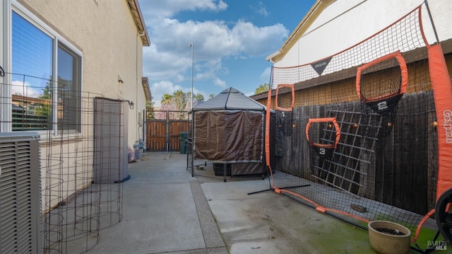 view of patio / terrace featuring a gate, central AC unit, and fence