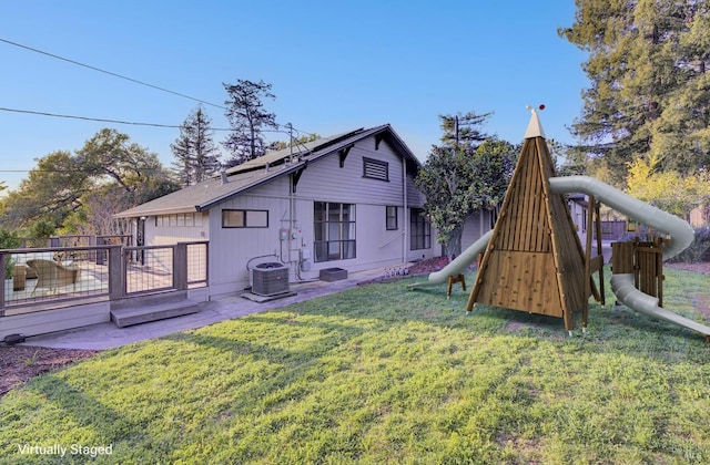 back of property with a playground, fence, central air condition unit, a yard, and a patio area