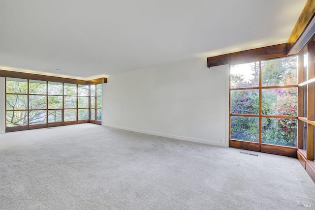 unfurnished room featuring a wall of windows, baseboards, carpet floors, and visible vents