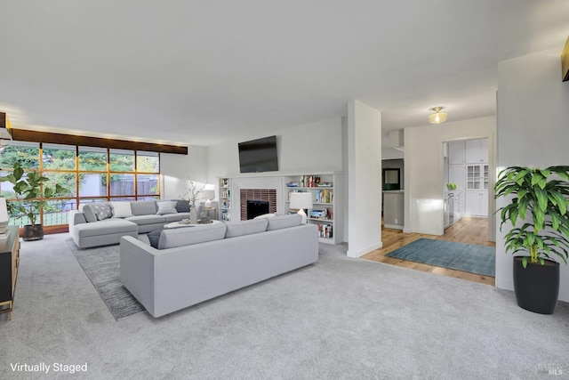 carpeted living room featuring a brick fireplace