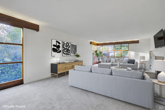 living area with a wealth of natural light, baseboards, carpet floors, and a fireplace