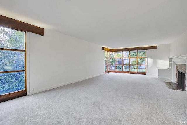 unfurnished living room with a fireplace, carpet, and baseboards