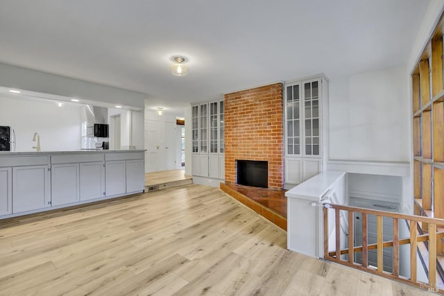 living room with visible vents, light wood-style flooring, and a fireplace