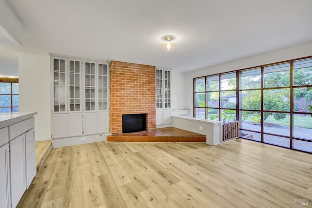 unfurnished living room featuring a fireplace and light wood finished floors