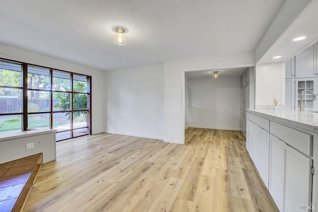 interior space with baseboards, light wood finished floors, and a sink