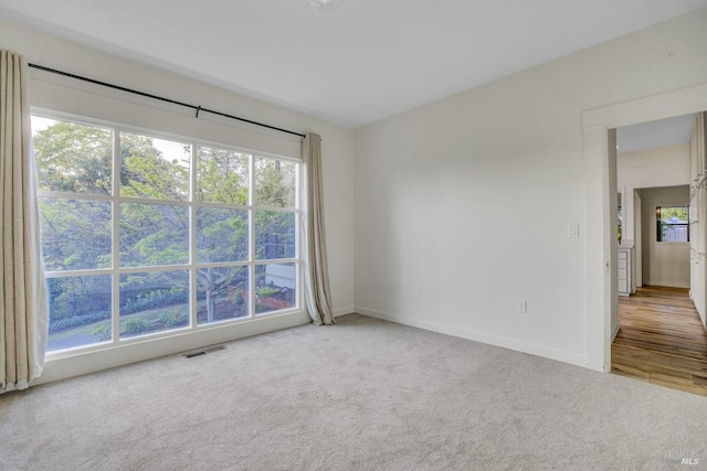 carpeted spare room with baseboards and visible vents