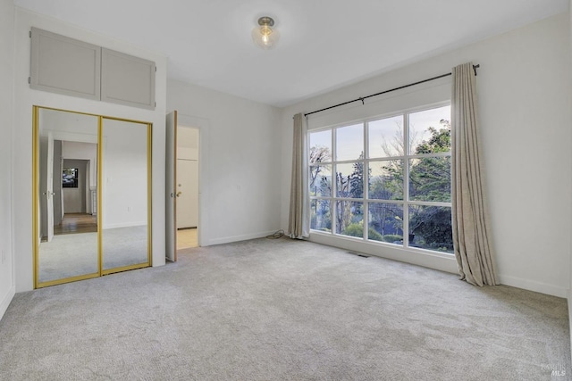 unfurnished bedroom with visible vents, carpet floors, baseboards, and a closet