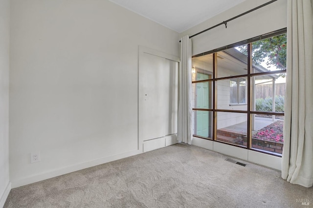 unfurnished room featuring visible vents, carpet flooring, and baseboards