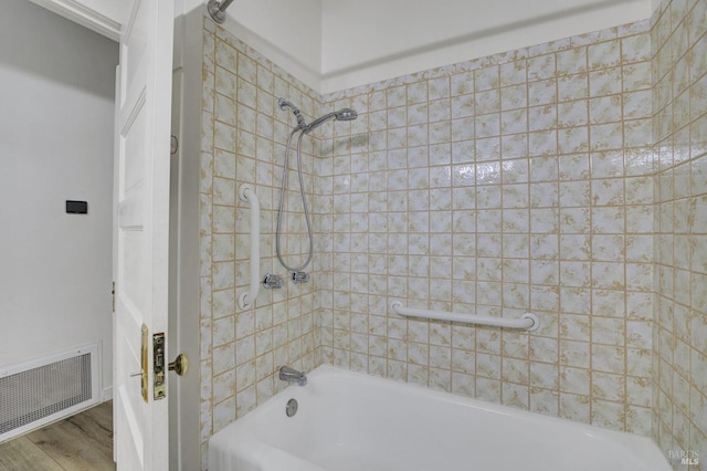 bathroom with visible vents, bathing tub / shower combination, and wood finished floors