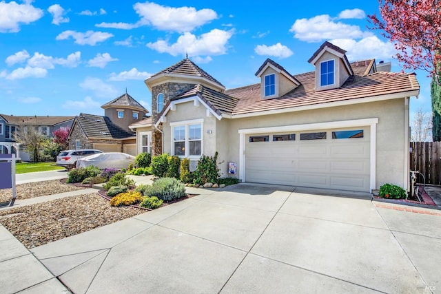 view of front facade with a tile roof, a garage, driveway, and stucco siding