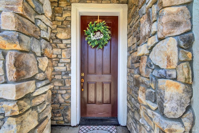 doorway to property featuring stone siding