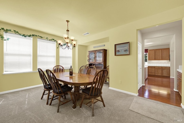 dining space with visible vents, baseboards, carpet floors, and an inviting chandelier
