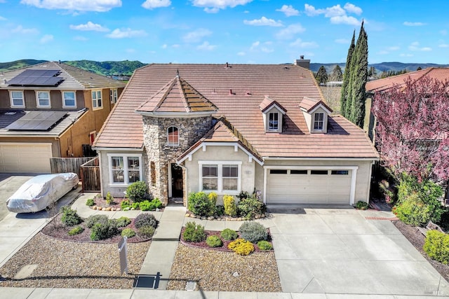 view of front of house featuring concrete driveway, stucco siding, fence, and a chimney