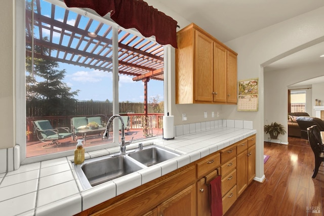 kitchen featuring a sink, tile counters, and wood finished floors