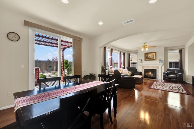 dining room featuring plenty of natural light, visible vents, wood-type flooring, and ceiling fan