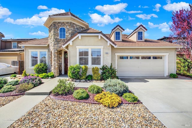 view of front of house featuring a tiled roof, stucco siding, a garage, stone siding, and driveway