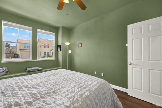 bedroom with a ceiling fan, baseboards, and dark wood-style flooring