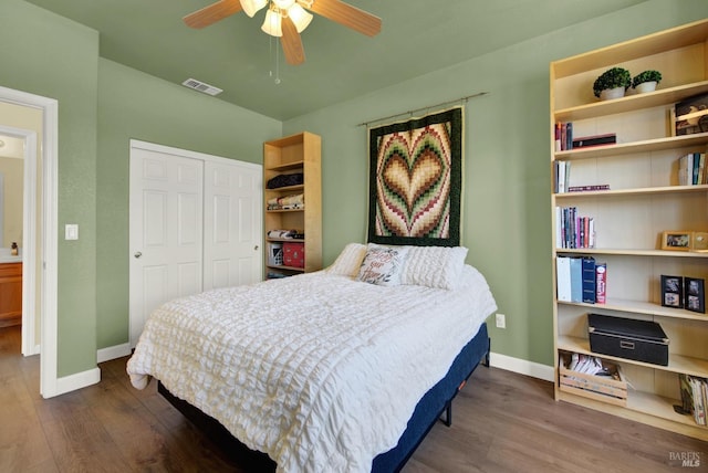 bedroom featuring visible vents, dark wood-type flooring, ceiling fan, baseboards, and a closet