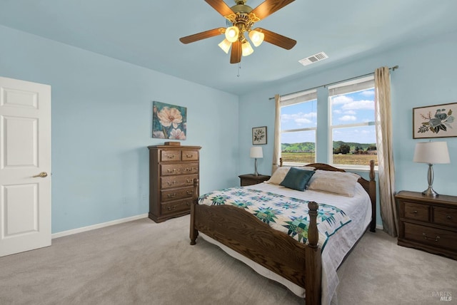 bedroom featuring visible vents, baseboards, light colored carpet, and ceiling fan