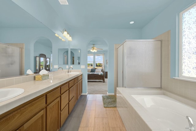 ensuite bathroom with a sink, connected bathroom, a stall shower, and double vanity