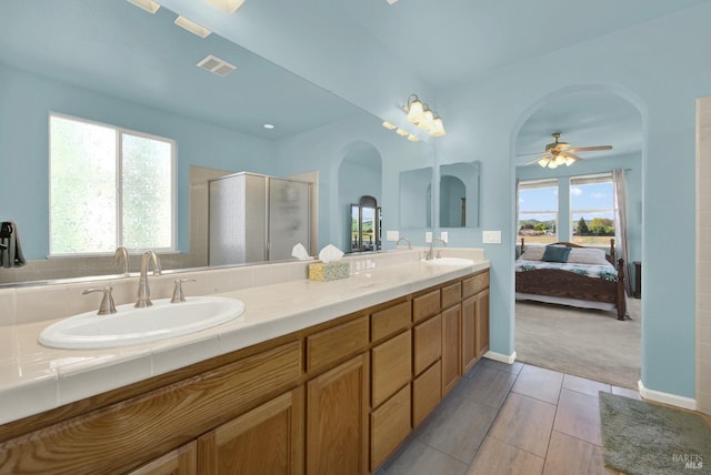 bathroom featuring a sink, visible vents, double vanity, and a shower stall