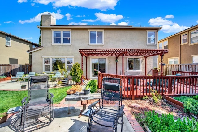 rear view of house featuring stucco siding, fence, a chimney, and a pergola