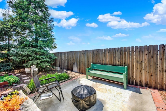 view of patio with fence and a fire pit