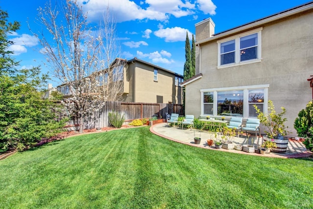 rear view of property with a patio, fence, a yard, stucco siding, and a chimney