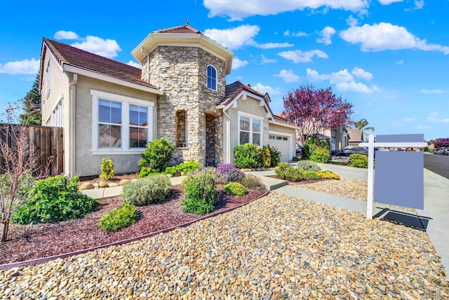 traditional-style house with stucco siding, concrete driveway, a garage, stone siding, and a tiled roof