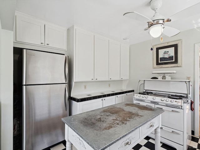 kitchen with double oven range, white cabinets, a center island, and freestanding refrigerator