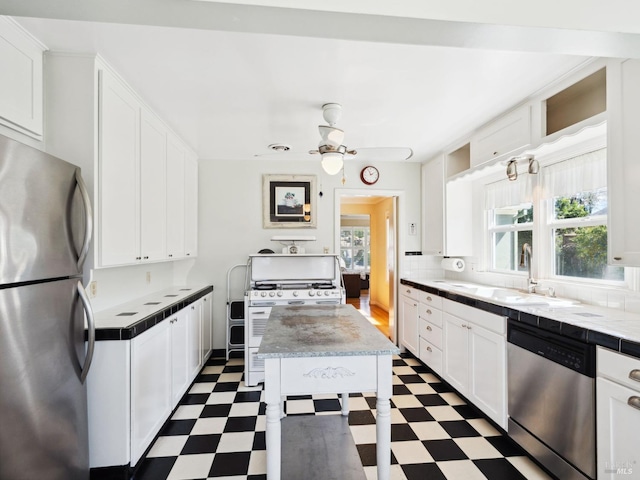 kitchen featuring white cabinetry, tile patterned floors, a healthy amount of sunlight, and stainless steel appliances