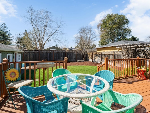 deck with outdoor dining area, a yard, and a fenced backyard