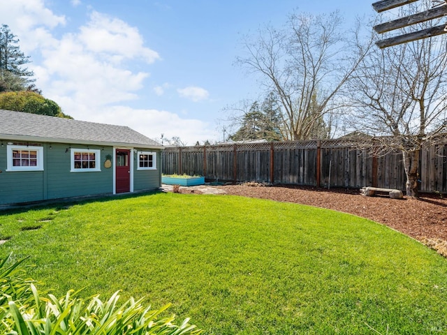 view of yard with an outdoor structure and a fenced backyard