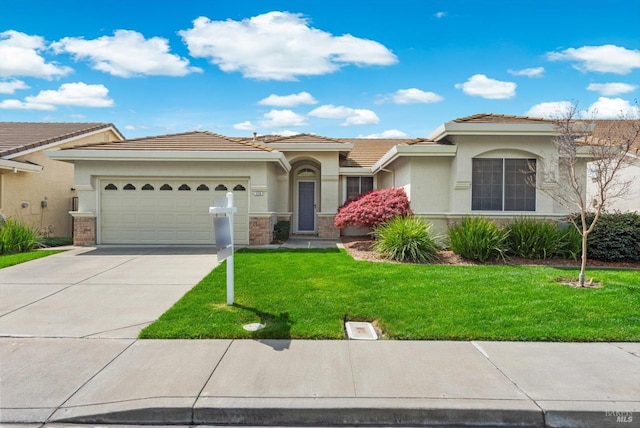 view of front of property featuring driveway, a front yard, an attached garage, and stucco siding