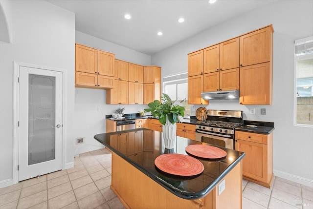 kitchen featuring dark countertops, recessed lighting, a kitchen island, appliances with stainless steel finishes, and under cabinet range hood