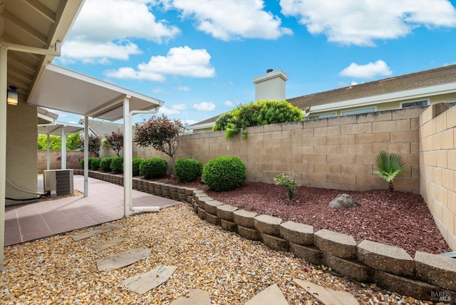 view of yard with a fenced backyard, central AC unit, and a patio area