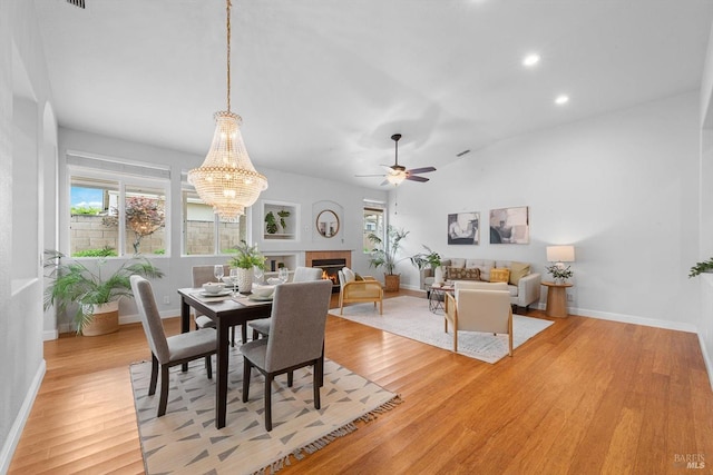 dining area featuring a wealth of natural light, light wood-style flooring, and ceiling fan with notable chandelier