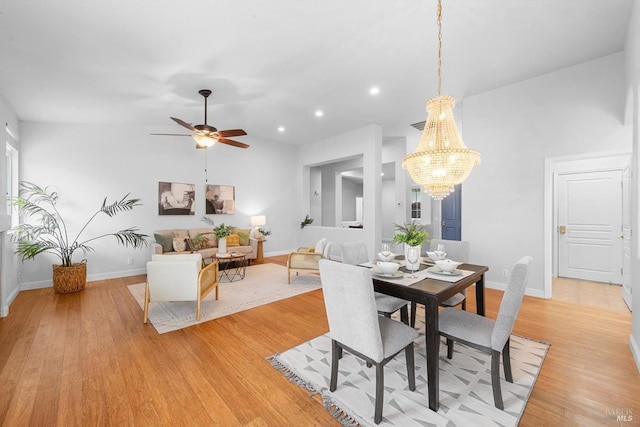 dining room featuring baseboards, recessed lighting, light wood-style floors, ceiling fan with notable chandelier, and vaulted ceiling