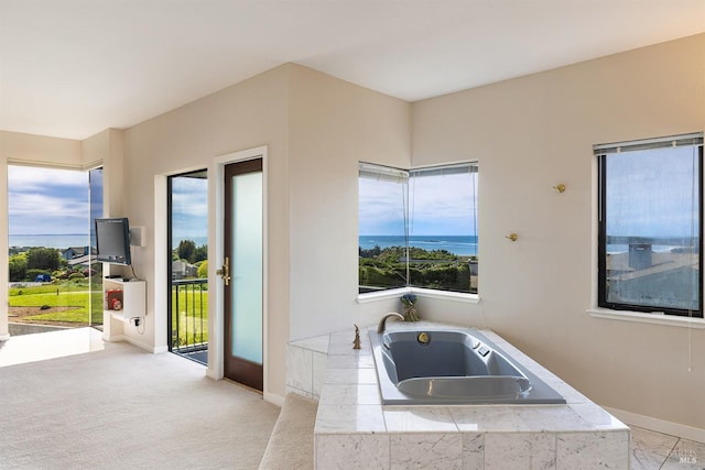 bathroom featuring a sink, baseboards, and tiled tub