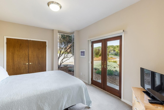 bedroom featuring baseboards, light colored carpet, french doors, a closet, and access to outside