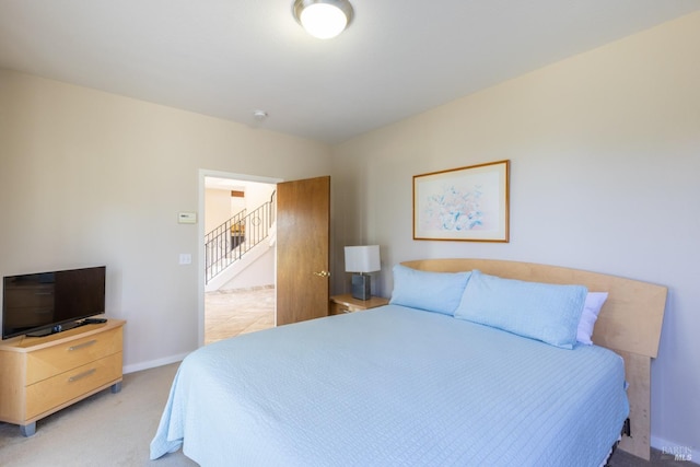 bedroom with light carpet and baseboards