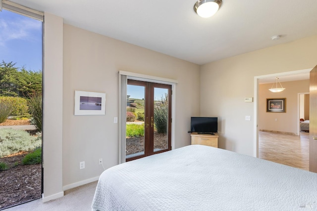 bedroom with light colored carpet, access to outside, french doors, and baseboards