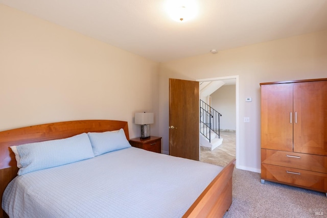 bedroom with baseboards and light colored carpet