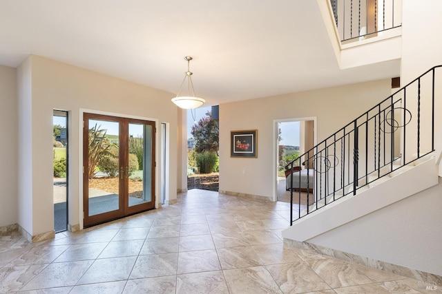 foyer entrance with french doors, a healthy amount of sunlight, and stairway